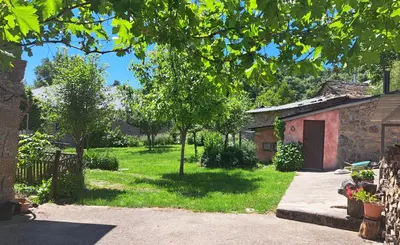 a yard with a stone building and a tree at Casa El Filandar in Ríonegrito