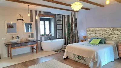 a bedroom with a bed and a tub and a sink at Casa El Filandar in Ríonegrito