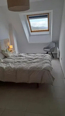 a bedroom with a bed and a chair and a window at Apartamento con vistas Barreiros in Barreiros