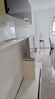 a white room with a tv sitting on a shelf at Apartamento con vistas Barreiros in Barreiros