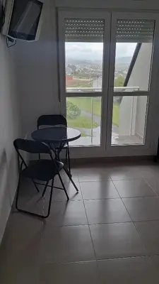 a table and a chair in a room with a window at Apartamento con vistas Barreiros in Barreiros