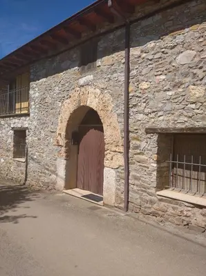 a stone building with a brown door on it at Casa Rural Borrenes las Médulas in Borrenes