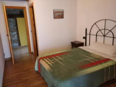 a bedroom with a bed with a green blanket at Casa Rural Borrenes las Médulas in Borrenes