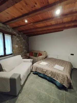 a bedroom with a bed and a couch in a room at Casa Rural Borrenes las Médulas in Borrenes