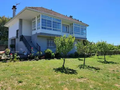 a house with a lot of windows in a yard at Casa vacacional amplia in Carracedo