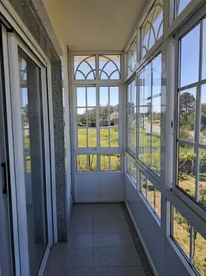 an empty room with large windows in a building at Casa vacacional amplia in Carracedo