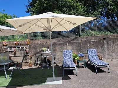a table and two chairs under an umbrella at Casa vacacional amplia in Carracedo