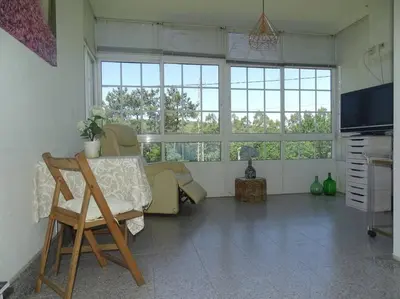 a room with a table and a chair and windows at Casa vacacional amplia in Carracedo