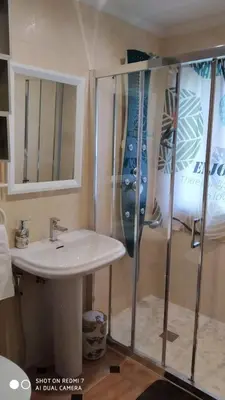 a bathroom with a sink and a glass shower at Apartamentos La Fuente Ribadeo in Ribadeo