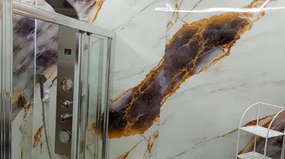 a bathroom with a marble wall at Apartamentos La Fuente Ribadeo in Ribadeo