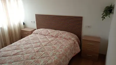 a bedroom with a bed and two night stands at Apartamentos La Fuente Ribadeo in Ribadeo