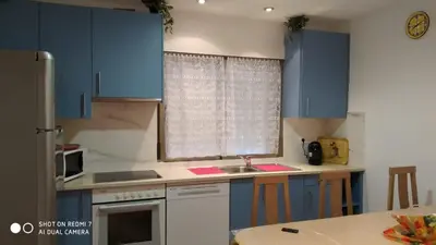 a kitchen with blue cabinets and a sink at Apartamentos La Fuente Ribadeo in Ribadeo