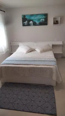 a bedroom with a large bed with a rug at Apartamentos La Fuente Ribadeo in Ribadeo