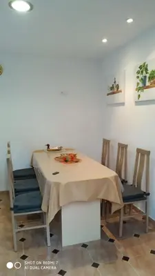 a dining room table with chairs and a table cloth at Apartamentos La Fuente Ribadeo in Ribadeo