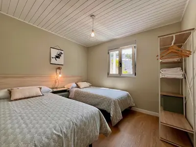 a bedroom with two beds and a window at Valdeflores flats in Viveiro