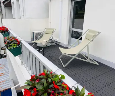 two chairs and a table on a balcony with flowers at Valdeflores flats in Viveiro
