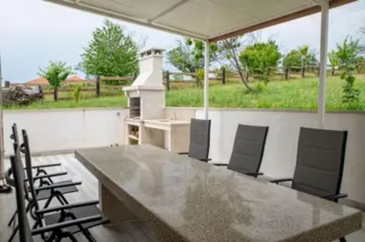 a patio with a table and chairs and a grill at Pepiño de Tomonte in Atrave