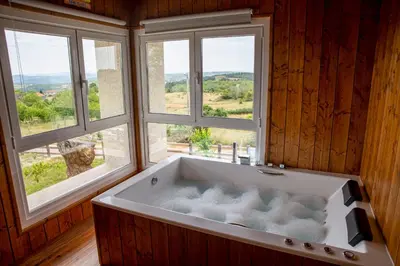 a bath tub in a room with two windows at Esperanza de a Trabe in Atrave