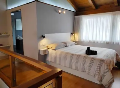 a bedroom with a bed with a black purse on it at Casa Merteira in Ourense