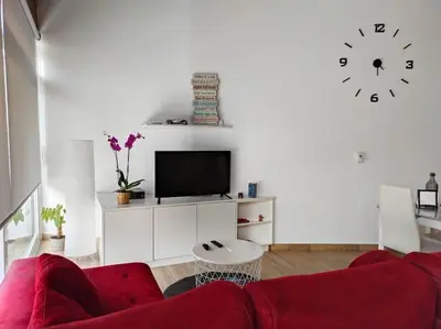 a living room with a red couch and a clock at Casa Merteira in Ourense