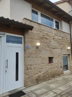 a stone building with a white door in front of it at Casa Merteira in Ourense