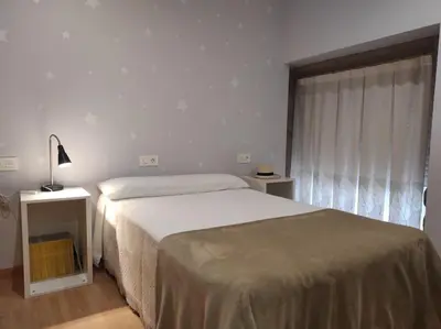 a bedroom with a large bed and a window at Casa Merteira in Ourense