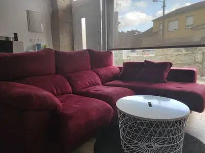 a living room with a red couch and a table at Casa Merteira in Ourense