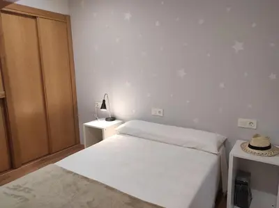 a white bedroom with a bed and a closet at Casa Merteira in Ourense