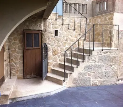 a stone building with a wooden door and stairs at Casa San Amaro in San Amaro