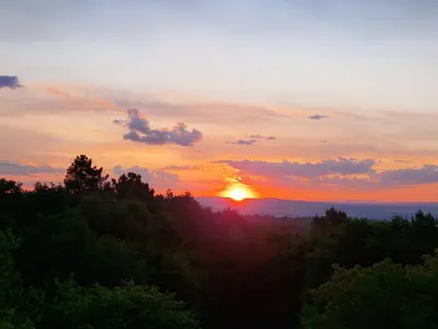 a sunset over a forest with the sun in the sky at Casa San Amaro in San Amaro