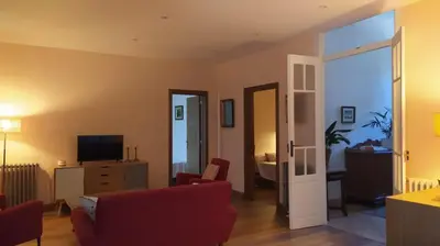 a living room with a red couch and a television at Casa San Amaro in San Amaro