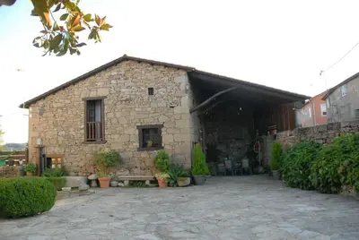 a stone building with plants in front of it at Lareira rural apartamento Ribeira Sacra Chantada in Chantada