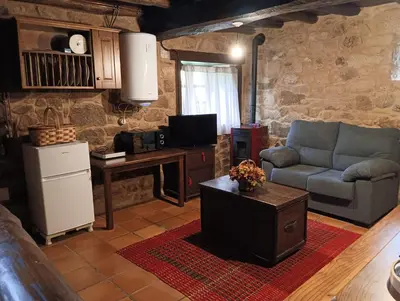 a living room with a couch and a table at Lareira rural apartamento Ribeira Sacra Chantada in Chantada