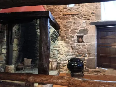a stone building with a vase on a table at Lareira rural apartamento Ribeira Sacra Chantada in Chantada