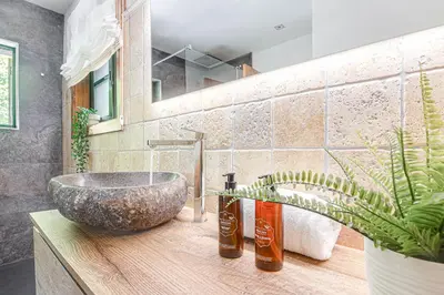 a bathroom with a stone sink on a wooden counter at Elysian Villa in Miño