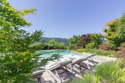 a swimming pool with two lounge chairs next to it at Elysian Villa in Miño