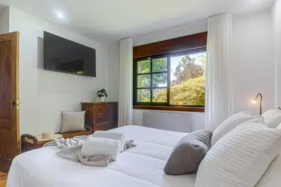 a bedroom with a white bed and a window at Elysian Villa in Miño