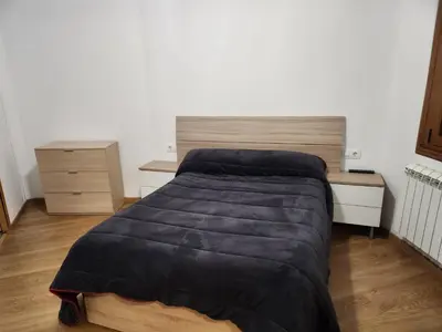 a bedroom with a bed and a wooden desk at Casa rural in Ourense