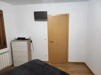 a room with a door and a television on a wall at Casa rural in Ourense