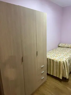 a bedroom with a bed and a large wooden cabinet at Casa rural in Ourense
