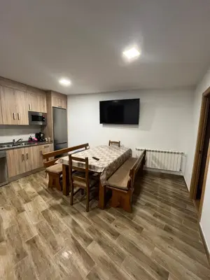 a room with a table and chairs and a kitchen at Casa rural in Ourense