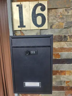 a mail box and a sign on a brick wall at Casa rural in Ourense