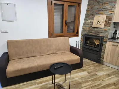 a living room with a couch and a fireplace at Casa rural in Ourense