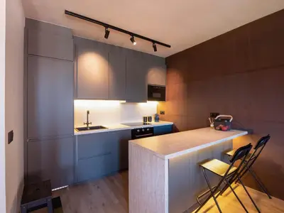 a kitchen with gray cabinets and a counter with chairs at La Fantástica Pontedeume 3 in Puentedeume
