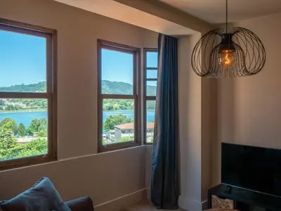 a living room with windows with a view of the water at La Fantástica Pontedeume 3 in Puentedeume
