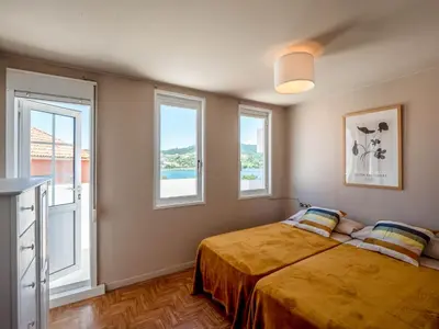 a bedroom with a bed and two windows at La Fantástica Pontedeume 4 in Puentedeume