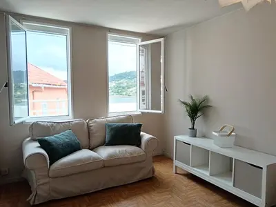 a living room with a couch and two windows at La Fantástica Pontedeume 4 in Puentedeume