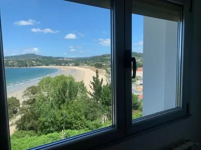 a window with a view of a beach and the ocean at Piso Miño con vistas in Miño