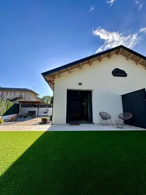 a white building with a green lawn in front of it at Ensueño in Molinaseca