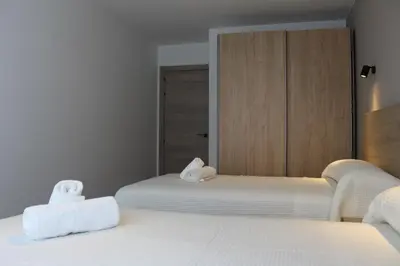 a bedroom with two beds with towels on them at Apartamentos Rego Foz in Foz